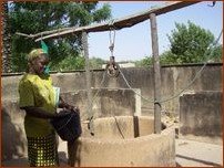 Une femme vient puiser l'eau au puits