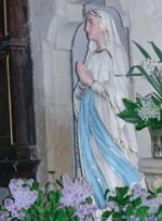 Notre-Dame de Lourdes devant laquelle étaient placés les Sœurs et les enfants, et devant laquelle « la dévouée servante » du Curé allait et venait…