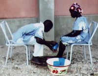 Session-Retraite « Cana ». Journée de la Réconciliation : Vincent s'incline pour laver les pieds de Solange. Diocèse de Manga, Burkina Faso