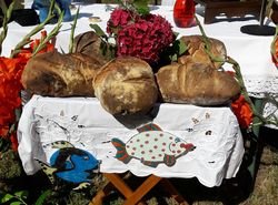 Sur la table de l'Eucharistie, 5 pains cuits au four du village et 2 poissons Sur la table de l'Eucharistie, 5 pains cuits au four du village et 2 poissons